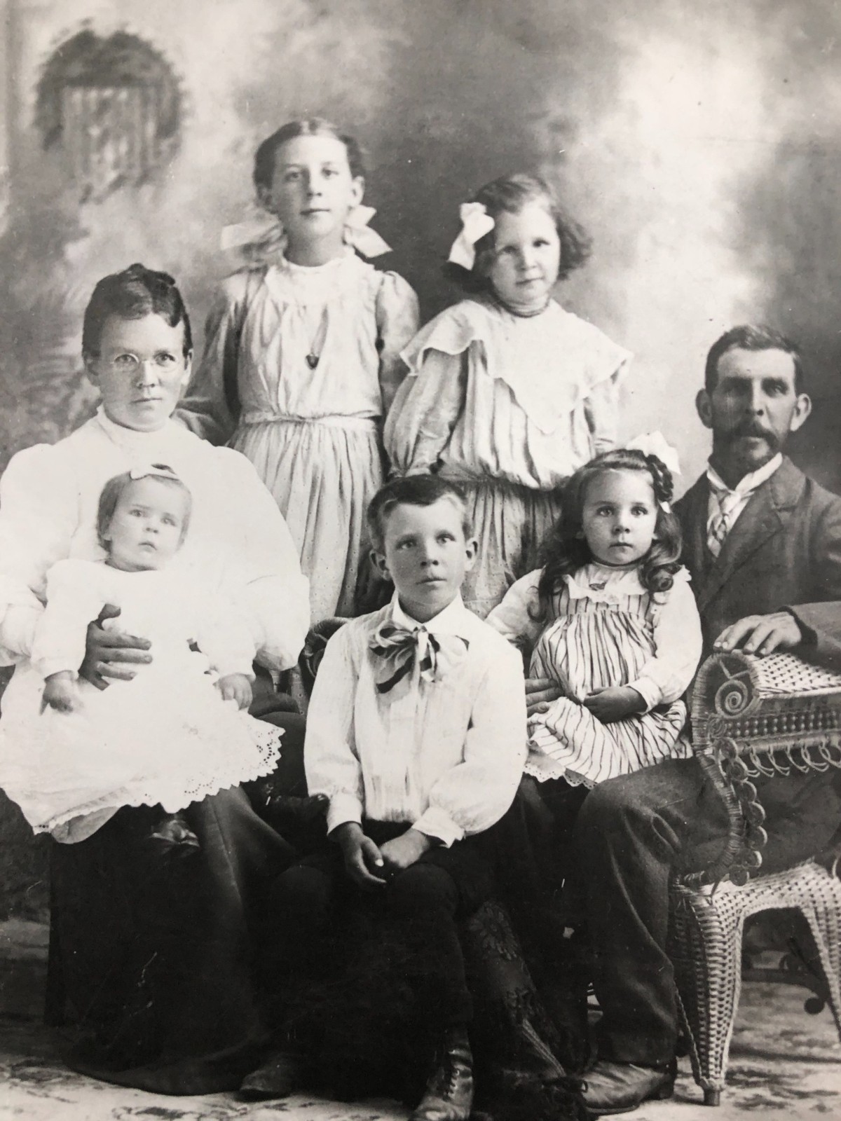 The Hopkins family. Back row: Violet and Ethel. Front row, left to right: Rosina holding Iris, Alma seated in the center, and Samuel holding Eleda.